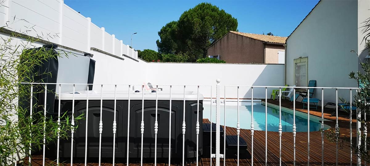 Spa ES76R au bord de la piscine sur une terrasse bois